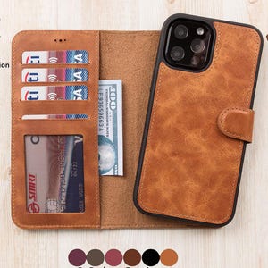 Könnte beinhalten: Eine braune Leder-Handyhülle im Brieftaschen-Design. Die Hülle hat Kartenfächer und eine Tasche für Bargeld. Das Telefon wird mit einem schwarzen Rahmen und einem Magnetverschluss gesichert. Der Text lautet "Full Covered Raised Edges for Max. Protection" und "GENIUE 100% LEATHER".
