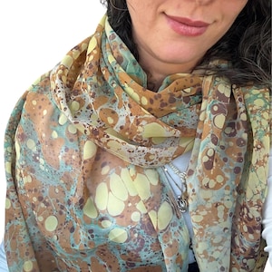 May include: A white ceramic mug with a black handle and the text "But First, Coffee" in a bold, black font. The mug is set against a neutral background, highlighting its simple design.