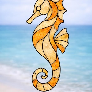Puede incluir: Un diseño de caballito de mar en vidriera en tonos naranja y beige, delineado en negro. El caballito de mar se encuentra sobre un fondo borroso de playa y océano, evocando un tema costero.