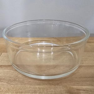 Puede incluir: Un tazón de mezcla de vidrio transparente con fondo redondeado y borde ancho.