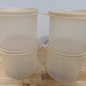 Puede incluir: Dos juegos de recipientes de almacenamiento de plástico transparente con tapas. Los recipientes están apilados uno encima del otro.
