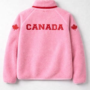 Peut inclure: Polaire rose avec col montant et bordure rouge. Le mot "CANADA" est brodé en rouge dans le dos, avec une feuille d'érable rouge sur chaque épaule. Vêtement chaud et confortable.