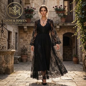 May include: A black floor-length dress featuring long sheer lace sleeves and a delicate floral lace overlay. The garment has a V-neckline and a fitted bodice that transitions into a flowing skirt. The Loom & Haven Home & Textiles logo is visible.