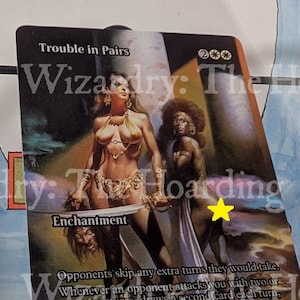May include: A collectible trading card titled "Trouble in Pairs" featuring fantasy art. The card depicts two female figures, one holding a sword and a severed head. The card has the text "Enchantment" and "BORIS 83".