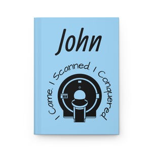Op de afbeelding: Een lichtblauw notitieboek met de naam "John" in zwarte letters. Daaronder een zwarte illustratie van een MRI-machine, omringd door de tekst "Came. I Scanned. I Conquered."