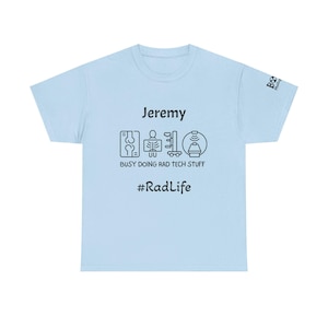 Può includere: T-shirt azzurra con il nome "Jeremy" e la frase "BUSY DOING RAD TECH STUFF" in testo nero. La maglietta presenta icone nere e l'hashtag "#RadLife".