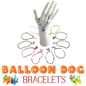 May include: A collection of beaded bracelets featuring small balloon dog charms in various colors. The bracelets are arranged around a white display hand, with the text BALLOON DOG BRACELETS displayed below along with small balloon dog illustrations.