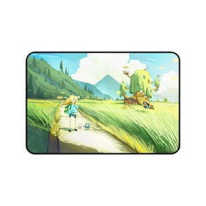 May include: A rectangular desk mat featuring a vibrant animated landscape illustration. A blonde character with a blue shirt and a small blue robot stand on a path in a grassy field. A large treehouse sits in the distance under a bright blue sky.