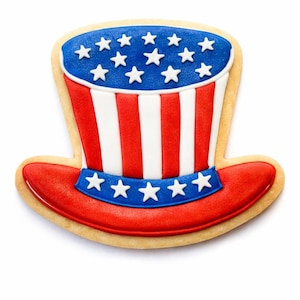 May include: A patriotic cookie shaped like an Uncle Sam hat. The hat features red and white stripes, a blue brim and crown adorned with white stars. The cookie is set against a white background.