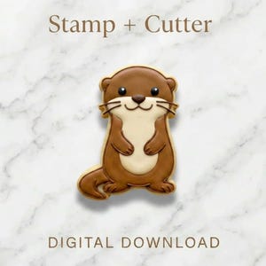 May include: A cookie cutter and stamp set featuring an otter design. The otter is brown with a cream-coloured belly and a smiling face. Text reads "Stamp + Cutter" and "DIGITAL DOWNLOAD".