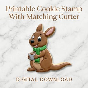 May include: A brown kangaroo cookie with a green scarf, holding a gray mug. The cookie is a stamp with a matching cutter, as indicated by the text "Printable Cookie Stamp With Matching Cutter" and "DIGITAL DOWNLOAD". The background is a marble pattern.