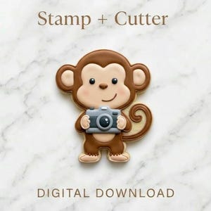 Könnte beinhalten: Ein affenförmiger Ausstecher mit einer Kamera. Der Keks ist braun, beige und hellbraun mit einer grauen Kamera. Der Text "Stamp + Cutter" und "DIGITAL DOWNLOAD" befinden sich oben und unten im Bild.