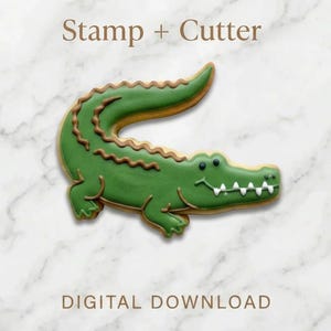 Può includere: Un set di taglia biscotti e timbro a forma di alligatore verde. Il biscotto è decorato con glassa verde, dettagli marroni e denti bianchi. Il testo "Stamp + Cutter" e "DIGITAL DOWNLOAD" è visualizzato su uno sfondo marmoreo.