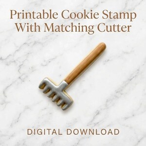 May include: A cookie cutter and stamp set in the shape of a rake, with a silver head and a wooden handle. The text "Printable Cookie Stamp With Matching Cutter" and "DIGITAL DOWNLOAD" are displayed.
