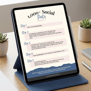 May include: A digital tablet displaying a guide titled "1,000+ Social Posts." The screen shows steps for scheduling posts, with a stylus resting on the side. The tablet is in a blue case, placed on a wooden desk, with a small plant in the background.