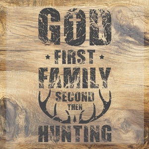 May include: A wooden background with the text "GOD FIRST FAMILY SECOND THEN HUNTING" in a distressed, dark gray font. The word "GOD" has a cross incorporated into the letter "O".