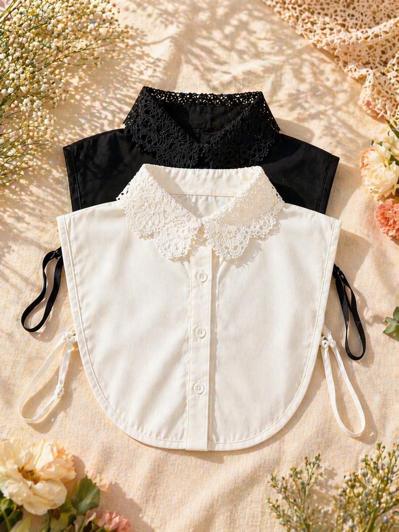 May include: Two detachable shirt collars, one white and one black, are displayed. The white collar has a delicate lace trim and a button-down front. The black collar features a similar lace trim. Both collars have attached ribbons.