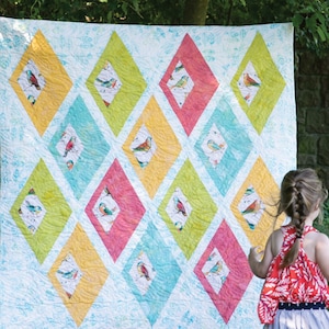 May include: A quilt with a diamond pattern featuring colorful birds on a white background. The quilt is made with a variety of fabrics, including yellow, green, blue, and pink.