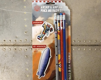 May include: A set of five pencils and two erasers with airplane and airship designs. The pencils are red, blue, yellow, and gray with white stars and stripes. The erasers are a blue airship and a red, white, and blue airplane. The packaging is red, white, and blue with the text "AIRSHIP & AIRPLANE PENCIL AND ERASER SET" and "BASED ON REAL MACHINES!"