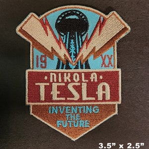 May include: A red, white, and blue embroidered patch with the text "Nikola Tesla Inventing the Future" and a stylized image of a Tesla coil. The patch is 3.5 inches by 2.5 inches.