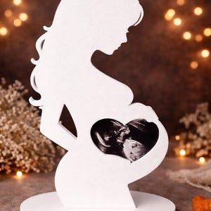 Puede incluir: Una taza de cerámica blanca con asa negra y el texto "But First, Coffee" en negrita negra. La taza se encuentra sobre un fondo borroso, resaltando su diseño limpio.