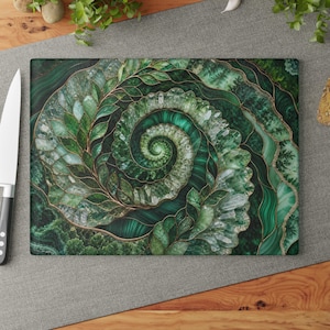 May include: A rectangular glass cutting board featuring a vibrant green spiral design composed of layered crystal formations and leaf-like patterns outlined in thin gold lines, set against a dark green malachite-inspired background.