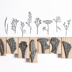 May include: Set of 10 wood mounted rubber stamps featuring different botanical illustrations of wildflowers and grasses. The stamps are arranged in two rows on a white background.