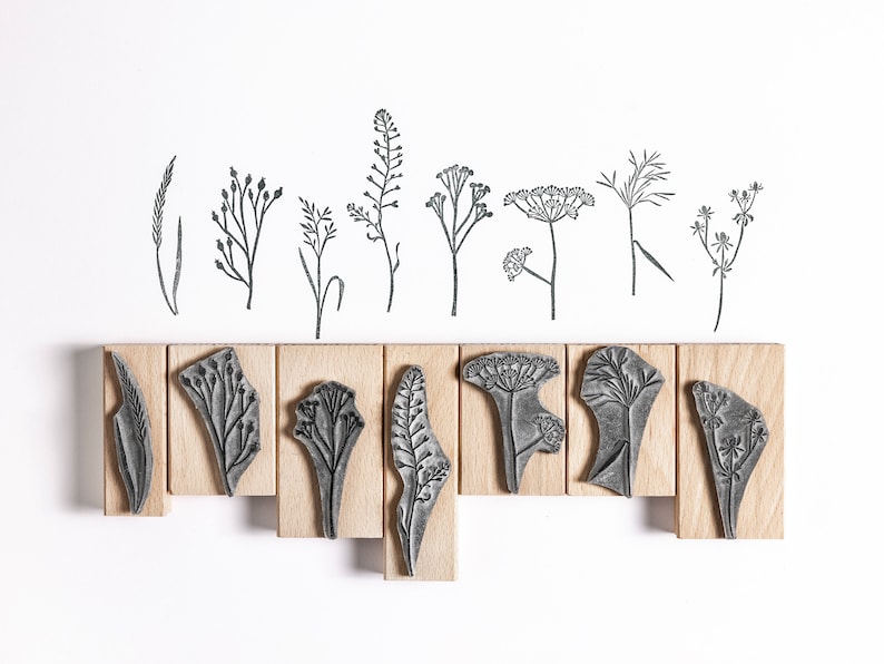 May include: Set of 10 wood mounted rubber stamps featuring different botanical illustrations of wildflowers and grasses. The stamps are arranged in two rows on a white background.
