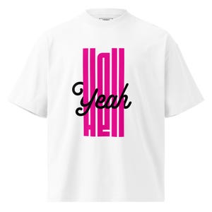 Puede incluir: Camiseta blanca con cuello redondo con un gráfico vertical rosa y la palabra "Yeah" en fuente cursiva negra. La palabra "Hell" también está en rosa, alineada verticalmente debajo de "Yeah".