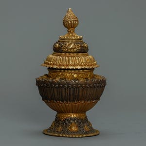 May include: A white ceramic mug with a black handle and the text "But First, Coffee" in a black, handwritten-style font. The mug is on a white surface.