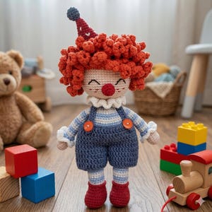 May include: A handmade crochet clown doll with red curly hair, a red nose, and a smiling face. The doll wears a striped shirt, blue overalls with orange buttons, and red shoes. A whimsical toy for children.