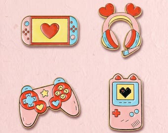 Könnte beinhalten: Ein Set aus vier Emaille-Anstecknadeln mit Gaming-Motiven: eine Handheld-Konsole mit rotem Herz-Bildschirm, ein rosa Kopfhörer mit herzförmigen Ohrmuscheln, ein rosa Gamecontroller mit roten Tasten und eine vertikale Konsole mit Pixel-Herz.