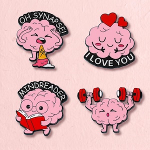 Könnte beinhalten: Vier Emaille-Anstecknadeln mit rosa Cartoon-Gehirnen. Eines zeigt ein Gehirn mit einer Eistüte und dem Text OH SYNAPSE!, eines mit Herzen und dem Text I LOVE YOU, eines beim Lesen eines roten Buches mit dem Text MINDREADER und eines beim Heben roter Hanteln.