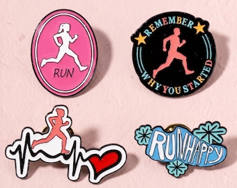 Könnte beinhalten: Vier Emaille-Anstecknadeln zum Thema Laufen. Ein rosa Oval mit weißem Läufer und dem Text RUN. Ein schwarzer Kreis mit rosa Läufer, gelben Sternen und dem Text REMEMBER WHY YOU STARTED. Ein Läufer mit Herzschlaglinie und rotem Herz. Ein blauer Anstecker mit dem Text RUNHAPPY.