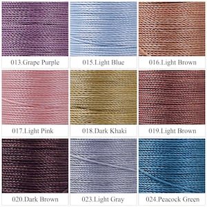 May include: A collection of nine spools of waxed thread in various colors, including Grape Purple, Light Blue, Light Brown, Light Pink, Dark Khaki, Light Brown, Dark Brown, Light Gray, and Peacock Green. Each spool is labeled with a number and color name.