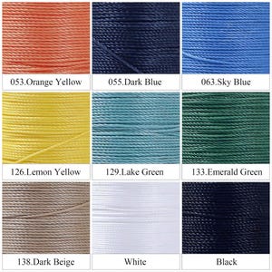 May include: A collection of colorful threads, including orange yellow, dark blue, sky blue, lemon yellow, lake green, emerald green, dark beige, white, and black. Each color is labeled with a number.