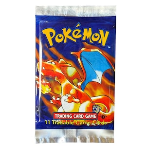 Peut inclure: Paquet scellé de cartes à collectionner Pokémon. L'emballage est bleu avec le logo Pokémon jaune. Une illustration de Charizard orange et rouge est présentée. Le paquet indique "11 cartes de jeu échangeables."