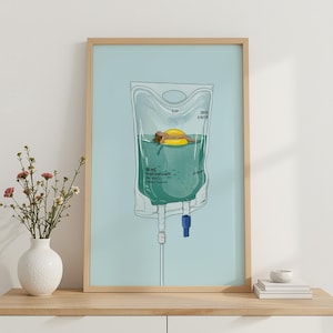 May include: Art print featuring a woman floating in a pool of teal liquid inside a medical IV bag. She is on a yellow inflatable ring. The background is a light blue color, and the print is in a wooden frame.