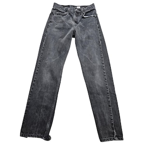 May include: A pair of faded black denim jeans. The jeans have a classic five-pocket design with a button and zipper closure. The denim has a slightly worn appearance.