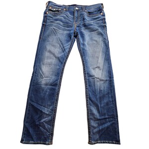 May include: Blue denim jeans with a classic five-pocket design. The jeans have a faded wash and feature decorative stitching along the seams and pockets. The jeans are a straight-leg style.