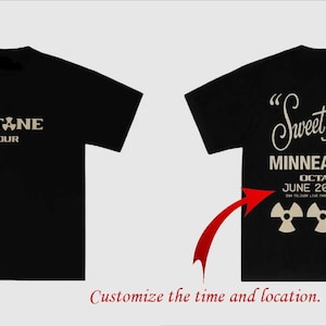 May include: A black short-sleeve t-shirt featuring a front graphic with the text OCTANE TOUR. The back displays the text Sweet Home, MINNEAPOLIS, OCTANE, JUNE 20, 2026, and three radiation symbols in a light beige color on the black fabric.