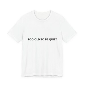 Könnte beinhalten: Ein weißes T-Shirt mit dem schwarzen Text "TOO OLD TO BE QUIET". Das T-Shirt hat einen Rundhalsausschnitt und kurze Ärmel. Der Text ist mittig auf der Vorderseite des Kleidungsstücks platziert.