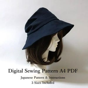 Pode incluir: Um chapéu azul marinho com aba larga, exibido em uma cabeça de manequim. O chapéu tem uma aparência macia e drapeada. O texto na imagem diz: "Digital Sewing Pattern A4 PDF, Japanese Pattern & Instructions, 3 Sizes Included."