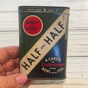 May include: A vintage green and white tin of Burley and Bright tobacco with the text "Half and Half" and "A Cargo of Contentment in the Bowl of Any Pipe".