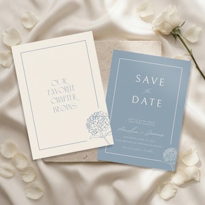 May include: Two rectangular wedding cards with blue line borders and hydrangea illustrations. The cream card reads "OUR FAVORITE CHAPTER BEGINS" and the blue card reads "SAVE THE DATE" with "Amelia & James" and event details in white text.