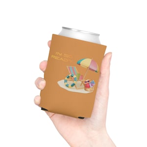 Könnte beinhalten: Ein beigefarbener Getränkekühler mit dem Text "I'M SO READY" und einer Strand-Szene-Illustration. Die Illustration zeigt einen Sonnenschirm, einen Liegestuhl, eine Schwimmweste und eine Strandtasche.