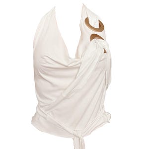 Könnte beinhalten: Weißes Neckholder-Top mit drapiertem Design. Das Oberteil hat einen Bindverschluss an der Taille und goldfarbene kreisförmige Akzente an den Schultern. Der Stoff scheint ein weiches, fließendes Material zu sein.