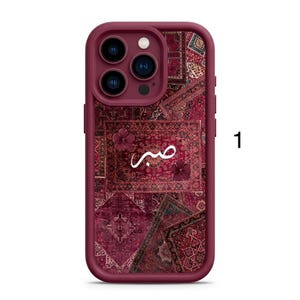 Peut inclure: Coque de téléphone bordeaux avec un motif de tapis. La coque présente une découpe pour l'appareil photo et le mot arabe « صبر » en écriture blanche. La coque a un pare-chocs protecteur et une esthétique élégante et moderne.
