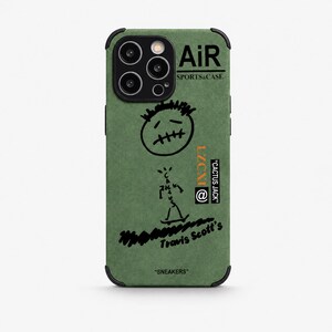 Peut inclure: Une coque de smartphone vert olive avec des impressions graphiques noires, dont une icône de visage cousu, un personnage en bâton sur un skateboard et le texte AiR SPORTS&CASE, CACTUS JACK, LZCX1 et Travis Scott's SNEAKERS avec un cadre photo noir.