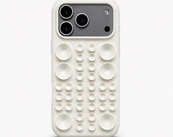 Op de afbeelding: Crèmekleurige telefoonhoes met een uniek textuurontwerp. De hoes heeft een reeks verhoogde, cirkelvormige elementen van verschillende grootte, waardoor een tastbaar oppervlak ontstaat. De camera is grijs met drie zwarte cameralenzen en een flitser.
